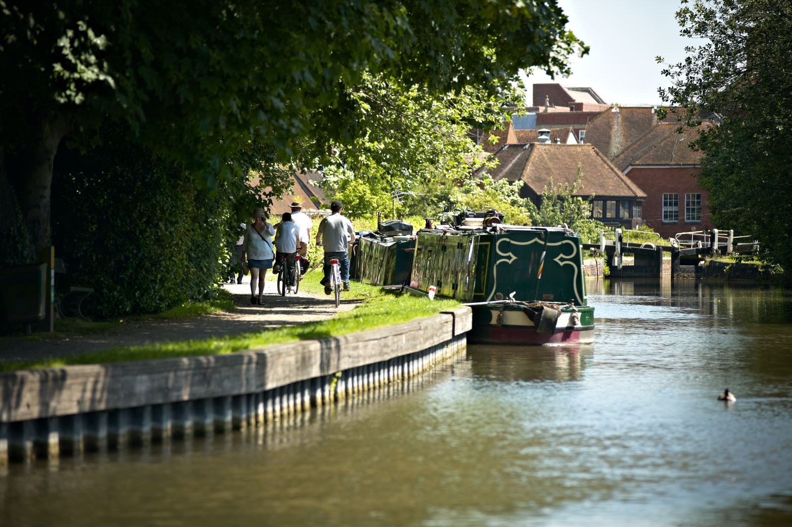 canal side with boat and people cycling